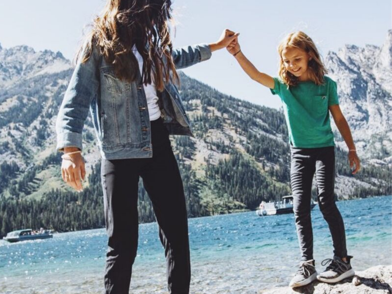 daughters dancing on rocks at beach in front of Jenny Lake